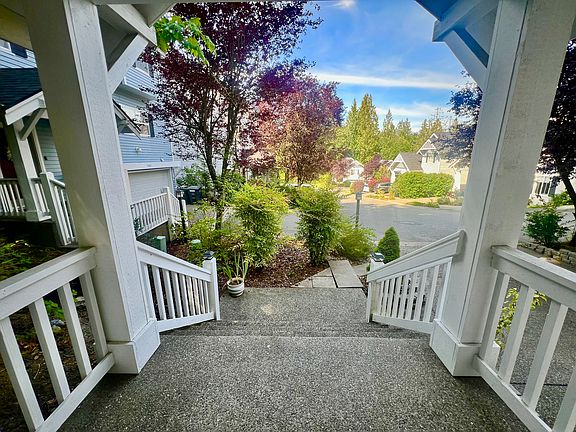 The front porch opens up to a low-maintenance landscaped yard bordered by cement blocks to keep the mulched plant beds tidy.