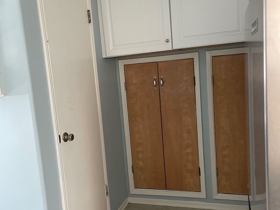 Additional cabinets in kitchen and closet or pantry space behind wooden doors. Door on left leads to bathroom