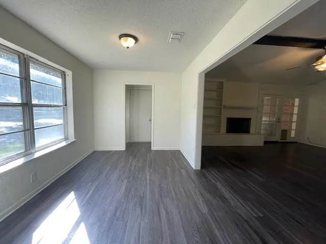 Unfurnished living room featuring a textured ceiling, dark hardwood / wood-style floors, and ceiling fan - 1016 Mistletoe Rd