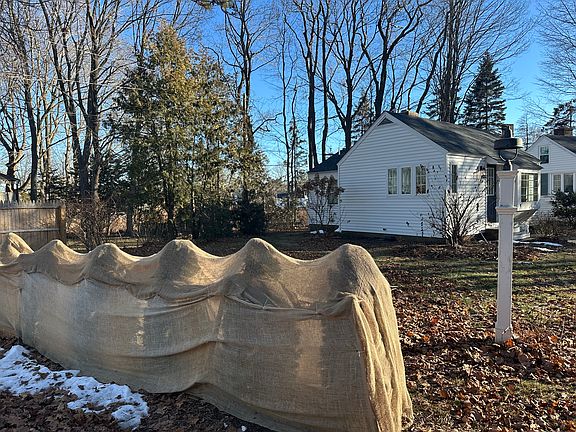 Side view from driveway, area behind covered bushes is the cottages yard.