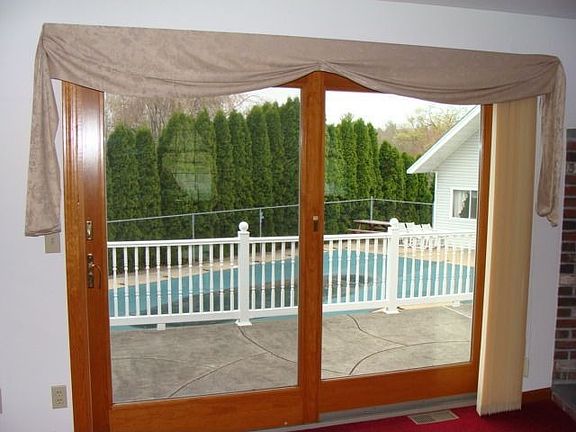 FR french door steps out onto the concrete deck overlooking the I/G pool