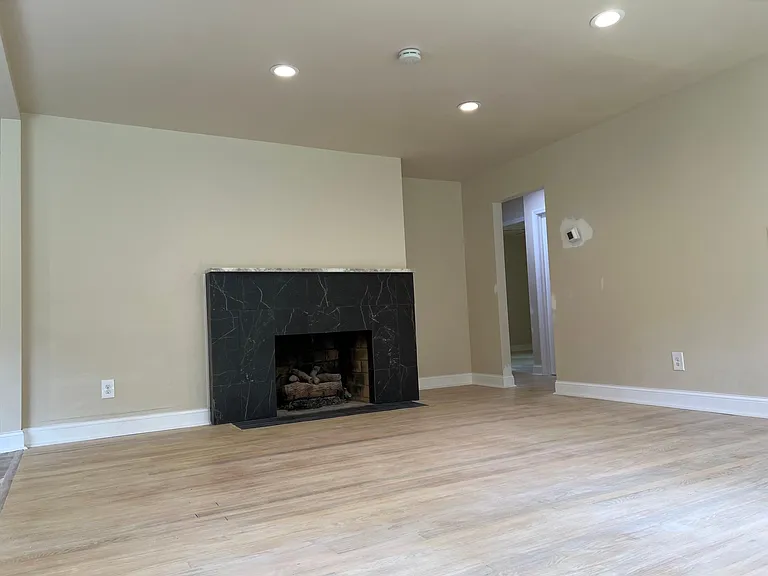 Bright and open living area with modern finishes, fresh paint, new floors, and cozy fireplace charm.