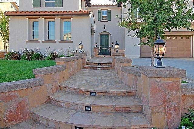 Elegant entry with stone steps and gated porch.
