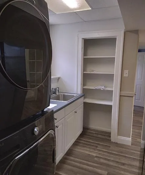 Shleving in Kitchen area along with full size washer and dryer, oven with stove top and refrigerator.