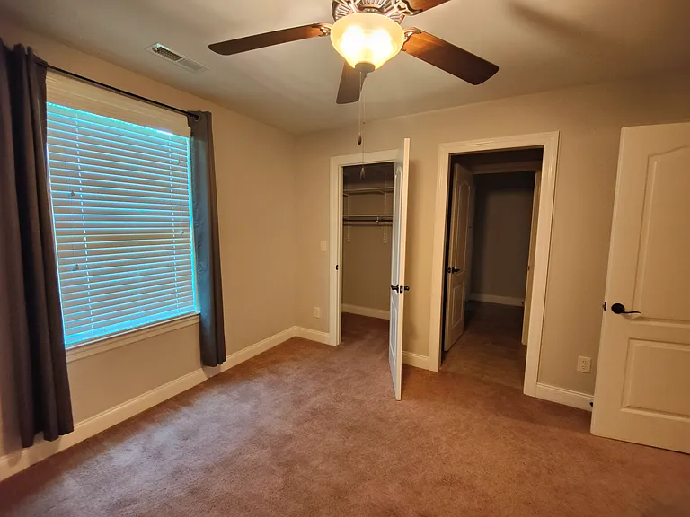 Upstairs bedroom with closet and walkway to bathroom.