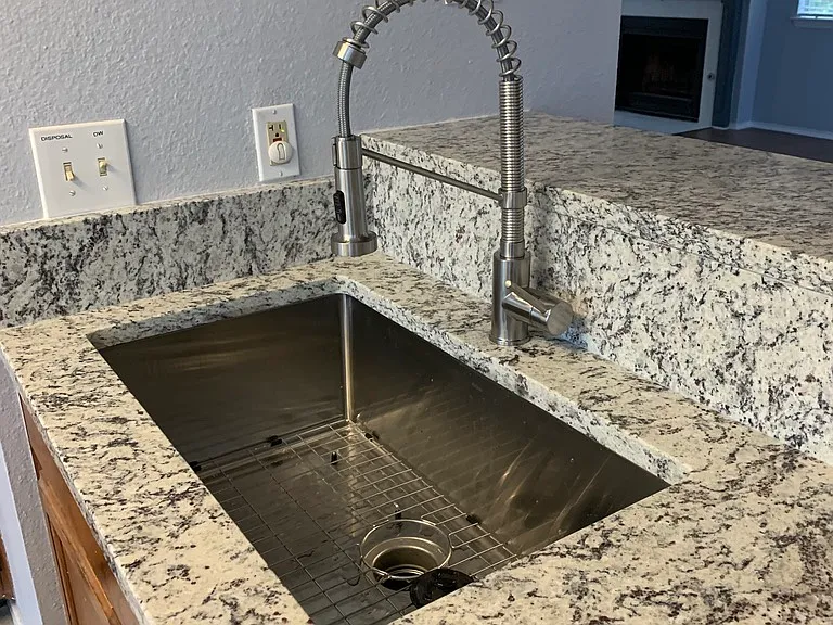 Deep single well sink and gooseneck sprayer nozzle for the sink.