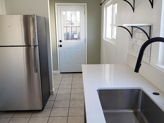 Spacious light filled laundry room in back of kitchen.