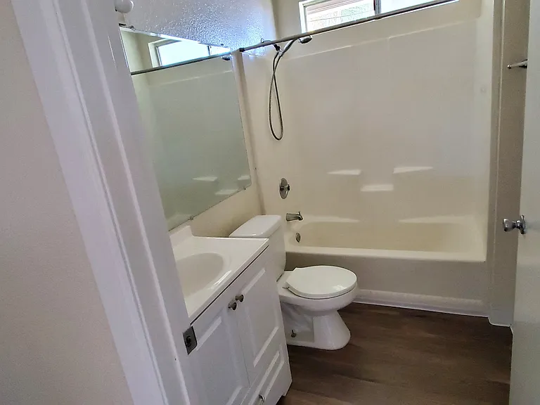 Bathroom with natural light and white cabinets at Zenith Place Apartments in Chula Vista, California.