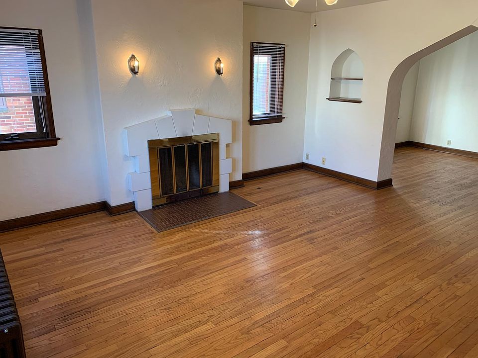 Living room with wood burning fireplace and ceiling fan.