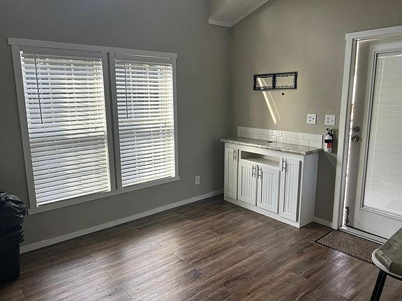 Open living room with built in shelving for extra storage. TV wall mount already installed