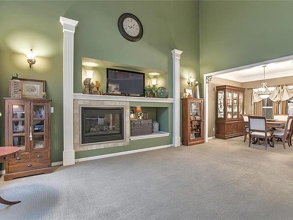 Great room has wonderful appeal with soaring ceilings, built-in for media and fireplace.