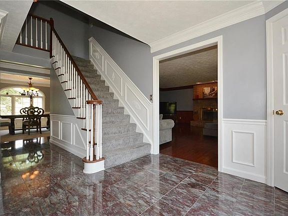 An elegant entry has modern colors & trim with classic marble tile floors