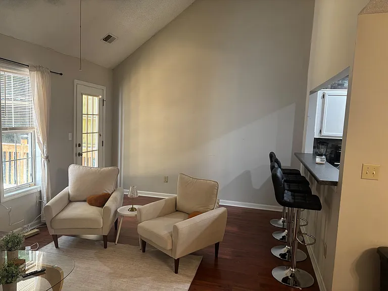 Open living area with seating nook, large window, and direct access to the patio; breakfast bar adds extra dining space.