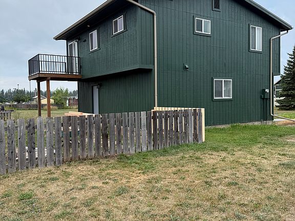 Back view with fenced back yard and upstairs deck