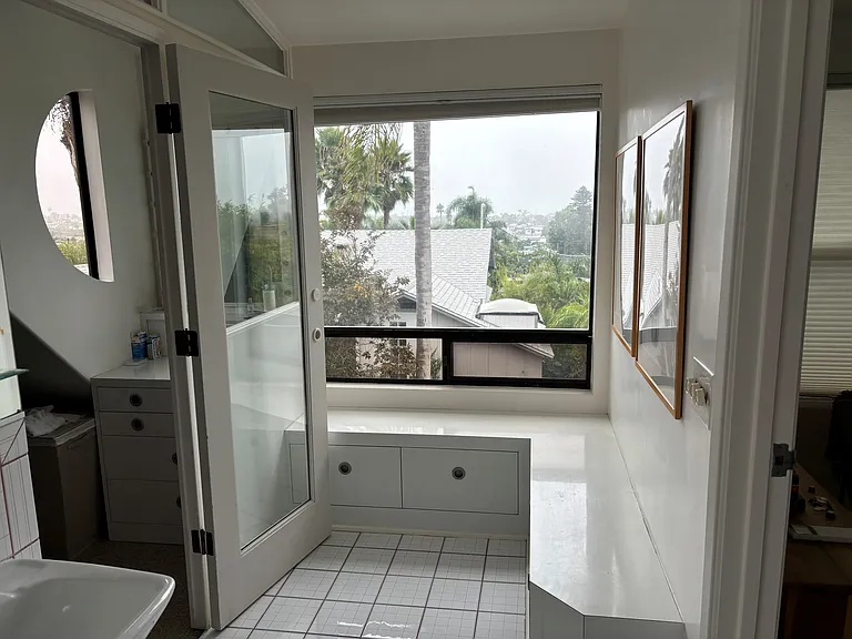 Seating area and more storage outside of closet and bathroom.