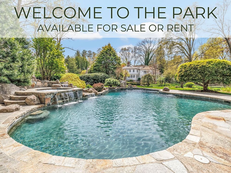 Beautiful free form gunite pool with cascading waterfall and integrated hot tub embodies the essence of relaxation and indulgence.