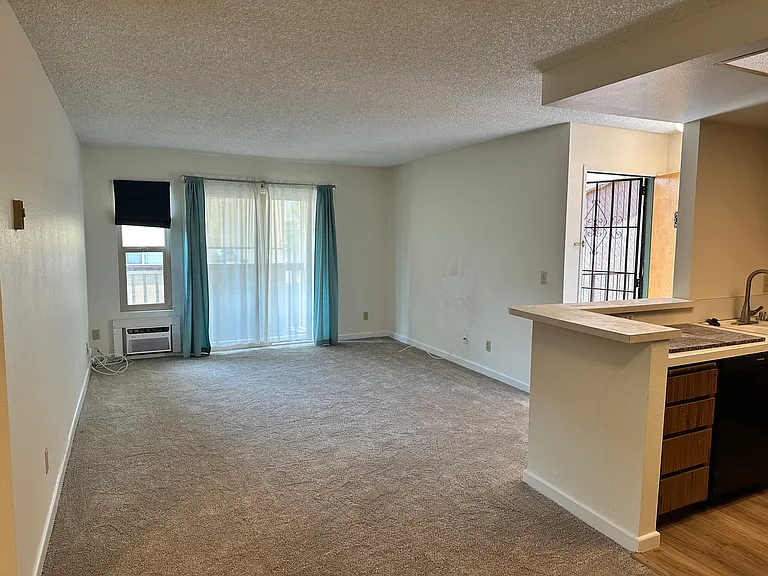 living room with AC wall unit and slider