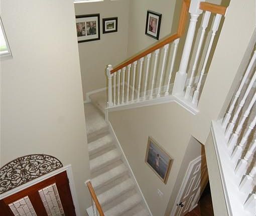 The leaded glass front door opens to attractive wood-like tile flooring and a soaring ceiling. You'll love the staircase.
