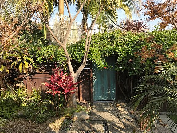 Enclosed front yard with garden and water fountain