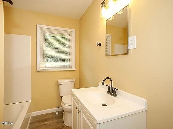 Clean bathroom with a vanity sink, neutral wall colors, and natural light from the window.
