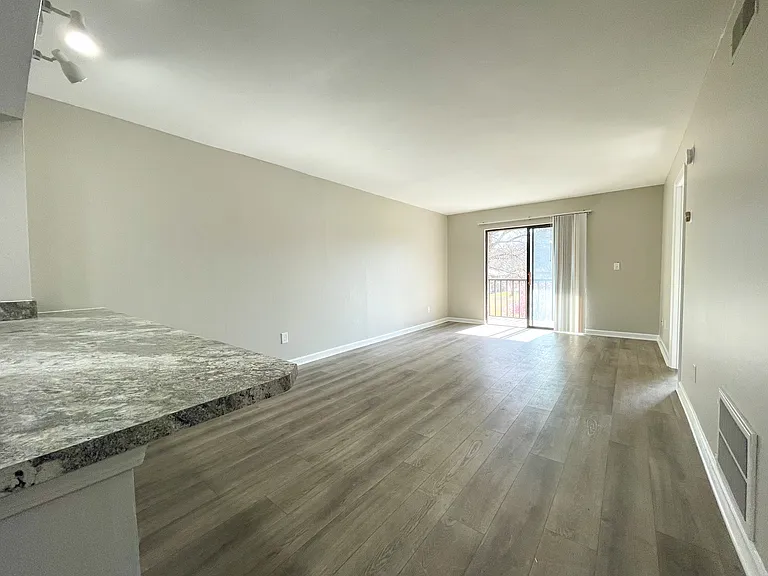 Open concept living room adjacent to the kitchen. The countertop is large enough for kitchen stools.
