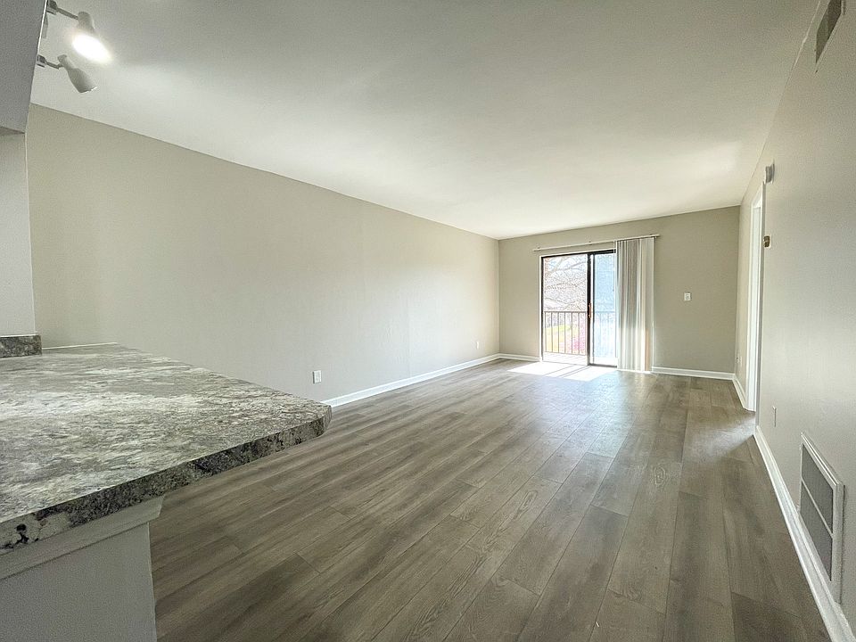 Open concept living room adjacent to the kitchen. The countertop is large enough for kitchen stools.