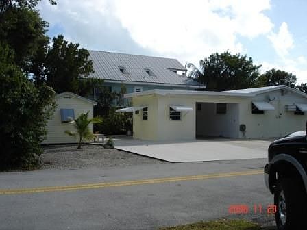 View of carport, 9x12 concrete shop, 10x12 modified aluminum shed, concrete parking area