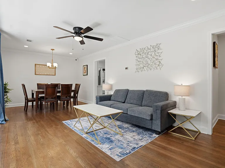 Open-concept living and dining area with hardwood floors, ceiling fan, and comfortable seating for relaxing or entertaining.