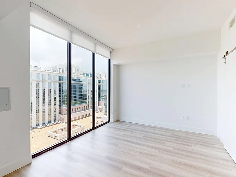Apartment Living Room with wood style flooring [and floor length windows.