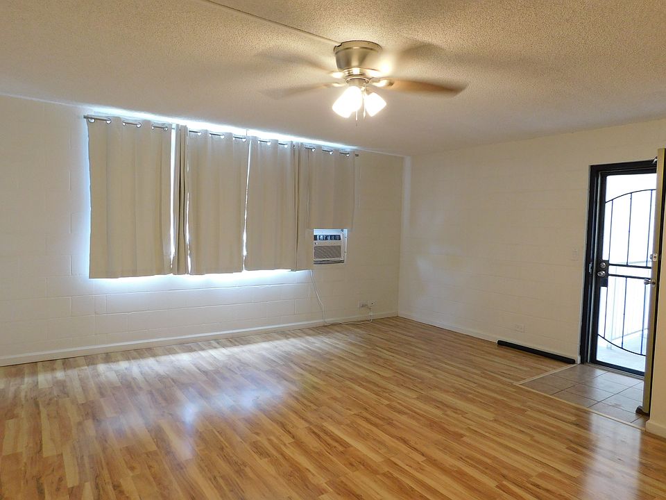 Living room with new drapes, new window A/C and new ceiling fan.