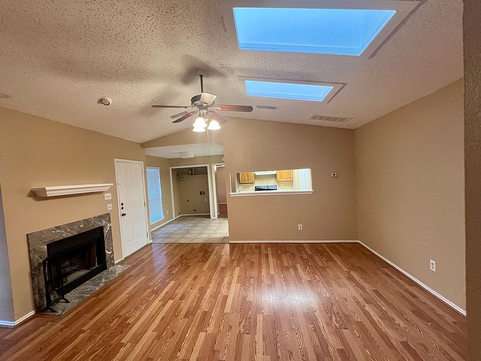 Bright living room with two skylights and wood burning fireplace.