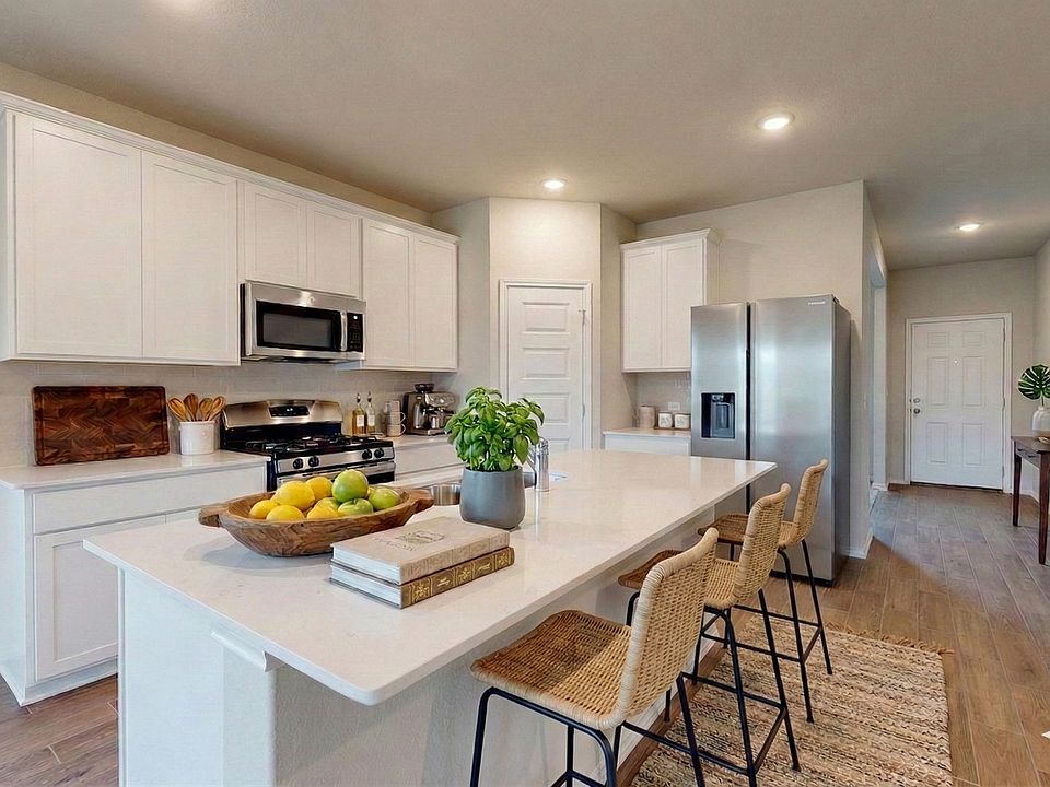 Chef's kitchen (staged) - with stainless steel appliances, large quartz island, a pantry and plenty of counter space