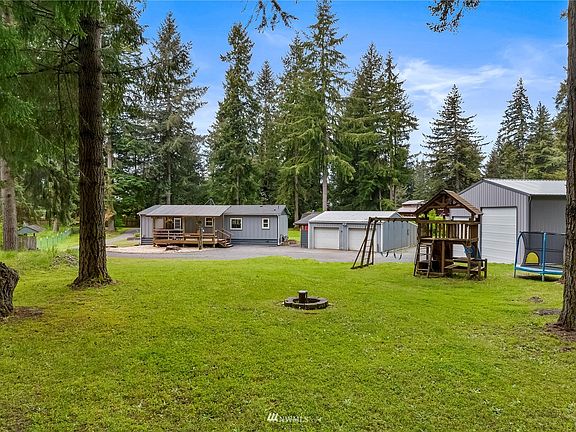 Great view taken from the back open space. Playground equipment and trampoline will go with sale of home.  Well head can be seen in open space.  