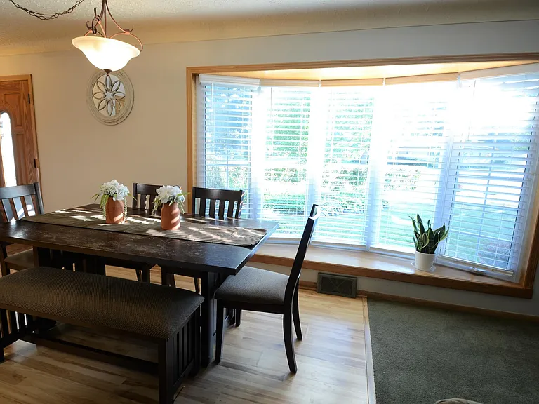 Dining room offers expansive views of front gardens. Open to kitchen and living room for socializing with friends and family. Low maintenance laminate wood floor makes clean-up a breeze.