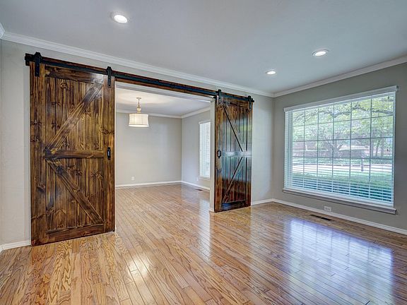 Office with barn doors dividing formal dining or bonus room.
