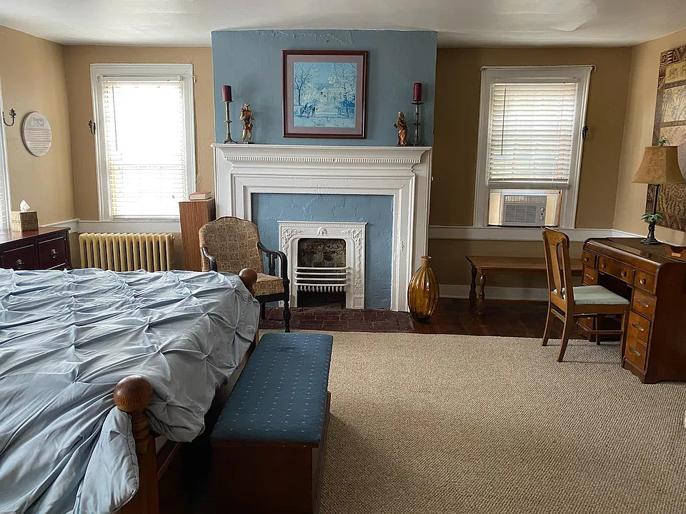Bedroom with fireplace and new window ac unit.
