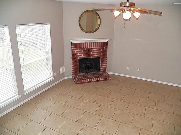 Cozy fireplace; windows overlook backyard.