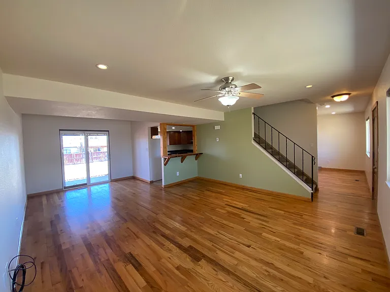 Bright and spacious living area with beautiful flooring, natural light, and plenty of room to relax and feel at home.
