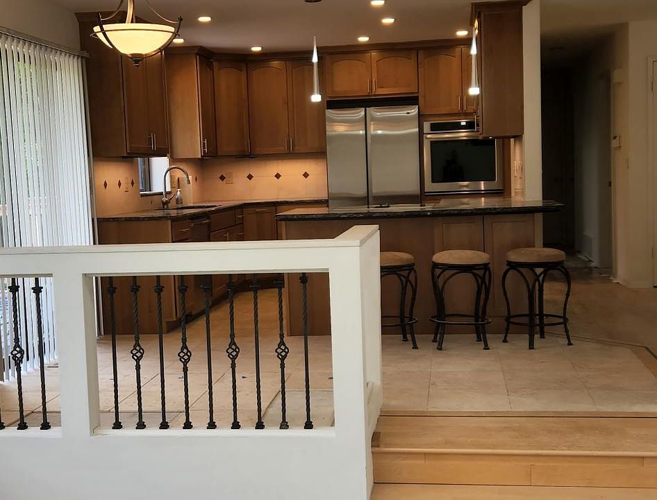 view into kitchen from the large family room with two skylights and vinal plank flooring .
