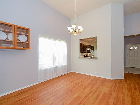 A view of the dining area with a pass through bar, all freshly painted in a neutral gray palette
