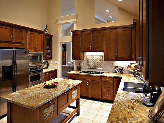 Gourment kitchen with beautiful slab granite, custom cabinetry and all stainless steel appliances remain with the home.