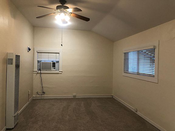 Living Room with High Ceilings, Ceiling Fan, Ceiling Lights and Window AC.