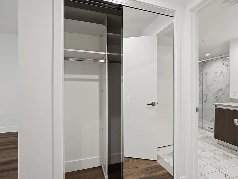 Bedroom with Mirrored Closet with Shelving, and Bathroom