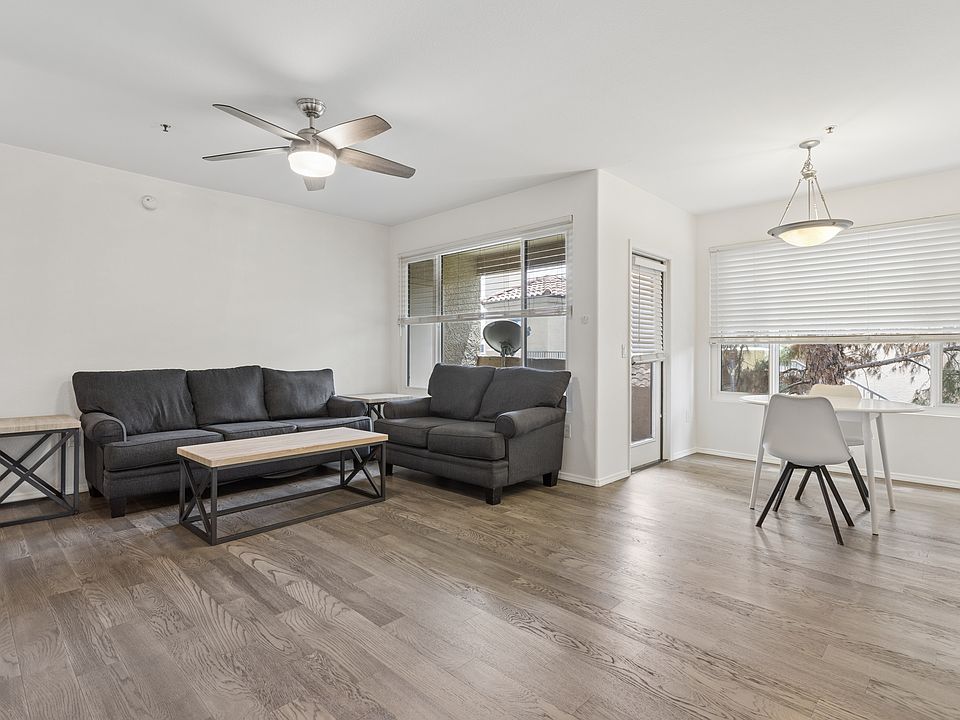 Large great room with new fan, new wood flooring, new windows, like new blinds, sofa and love seat and small table and chairs