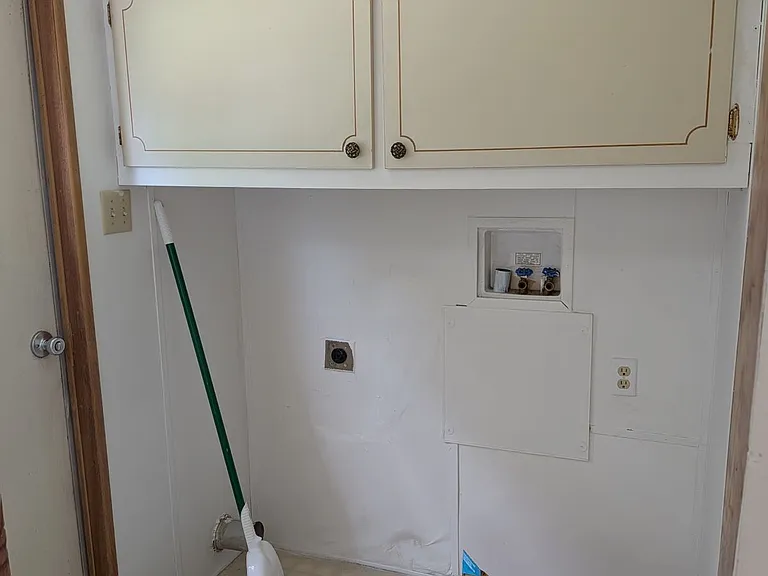 Laundry room with washer/dryer hookups, large upper cabinets, also has large pantry above AC filter access