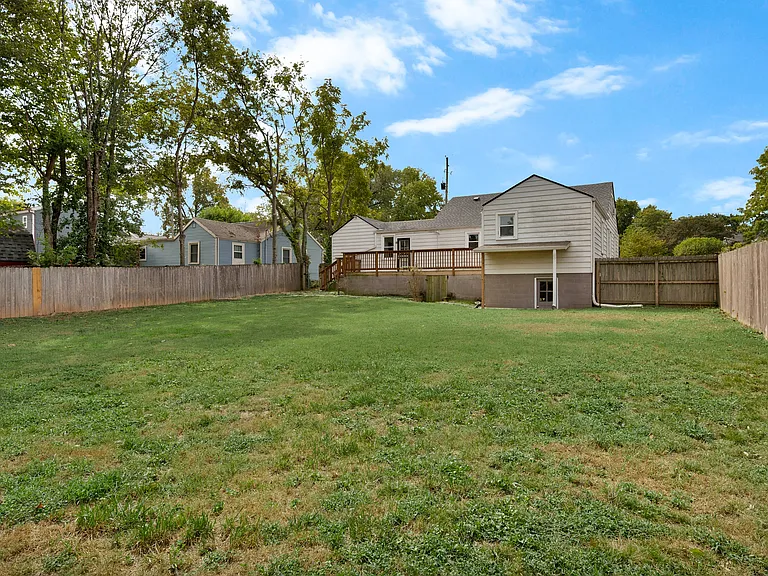Photo 26. Fenced-in Backyard with view of back deck and basement exit door