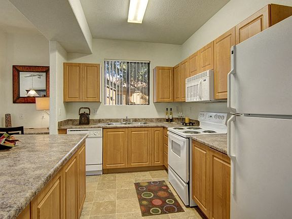 Arezzo Apartments- kitchen with white appliances and wooden cabinets