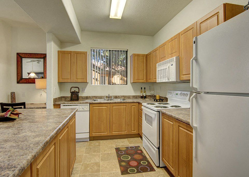 Arezzo Apartments- kitchen with white appliances and wooden cabinets