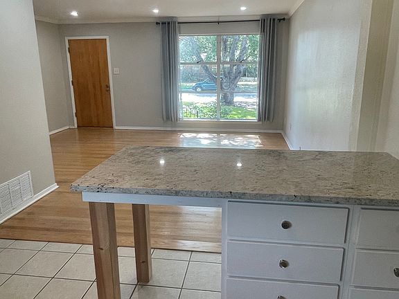 Island with granite counters, seating, and extra storage space