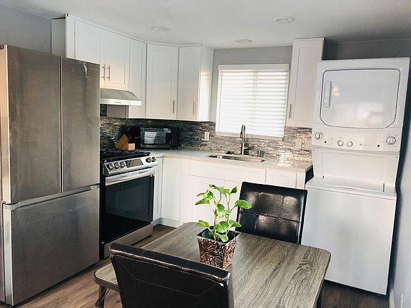 Close up of kitchen area with knife set, microwave, dinnerware, silverware